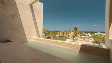 A balcony with a view of a beach and buildings.