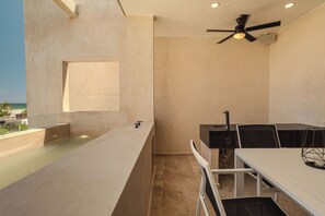 Una cocina moderna con una isla grande, un comedor con mesa y sillas, y un ventilador de techo.