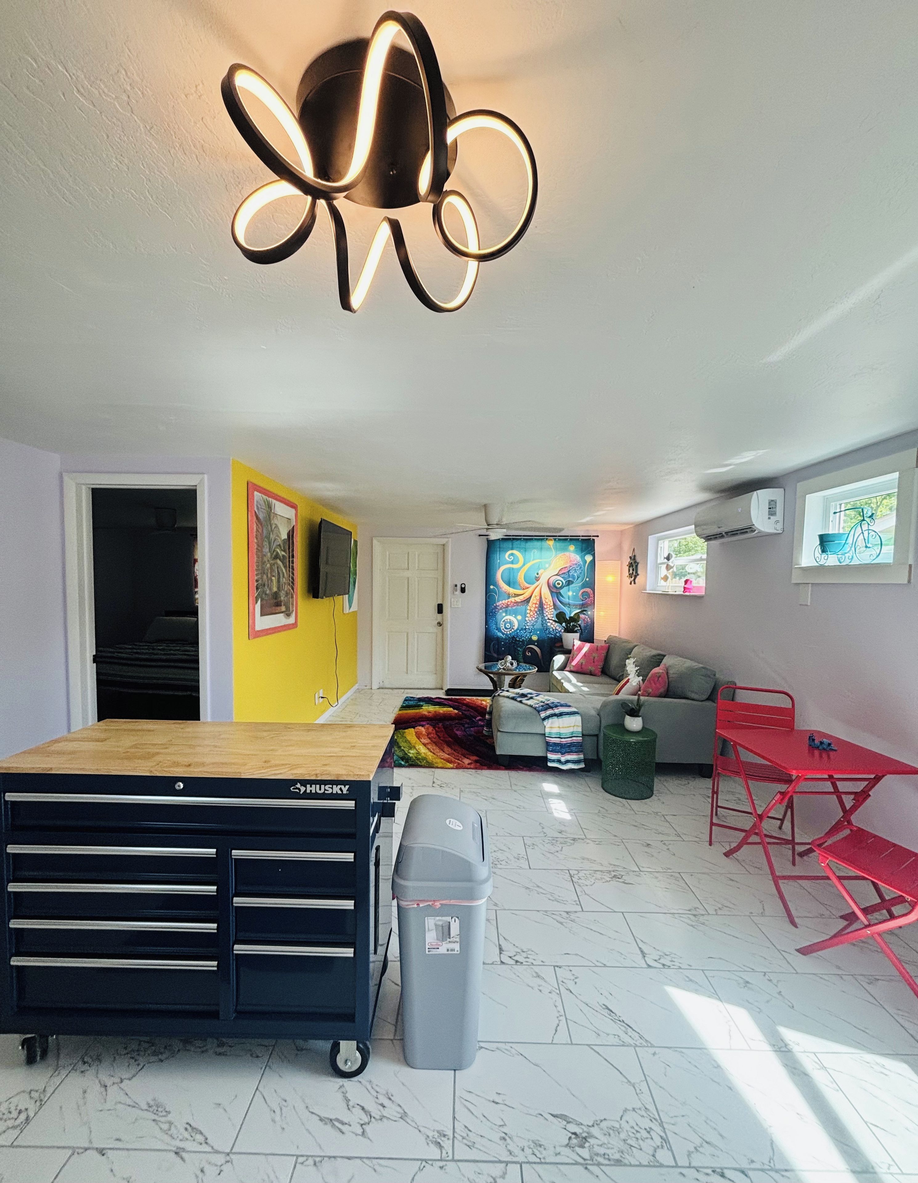 A compact living space with a bed, a desk, a sofa, and a TV.