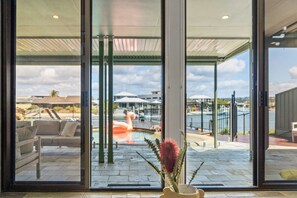 Ein modernes Interieur mit Blick auf einen Außenpool, eine Flamingoskulptur und einen Topfpflanzen.