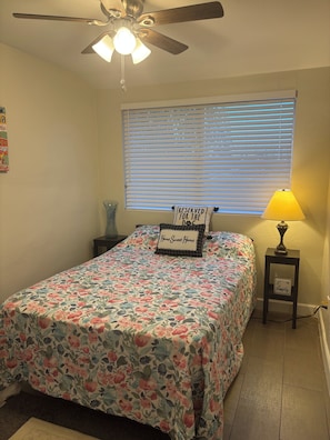 A bedroom with a bed, a ceiling fan, a window with blinds, a bedside lamp, and a small table. - Top-Floor Scottsdale Retreat - Pool, Spa & Near Old Town (Scottsdale)