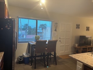 A compact kitchen with a dining area, a refrigerator, a TV, and a window with blinds. - Top-Floor Scottsdale Retreat - Pool, Spa & Near Old Town (Scottsdale)