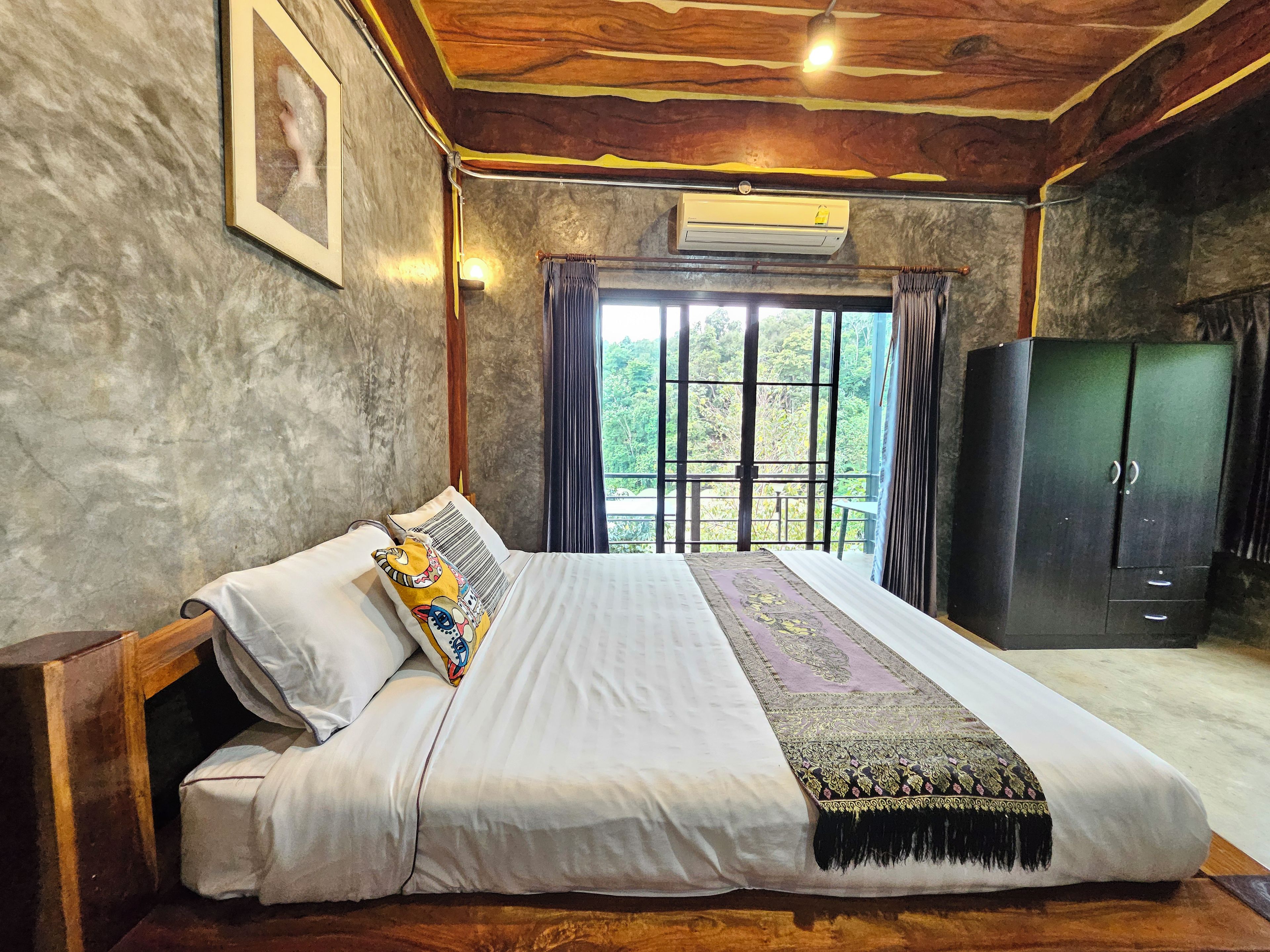Un dormitorio con una cama grande, un armario y una ventana con cortinas.