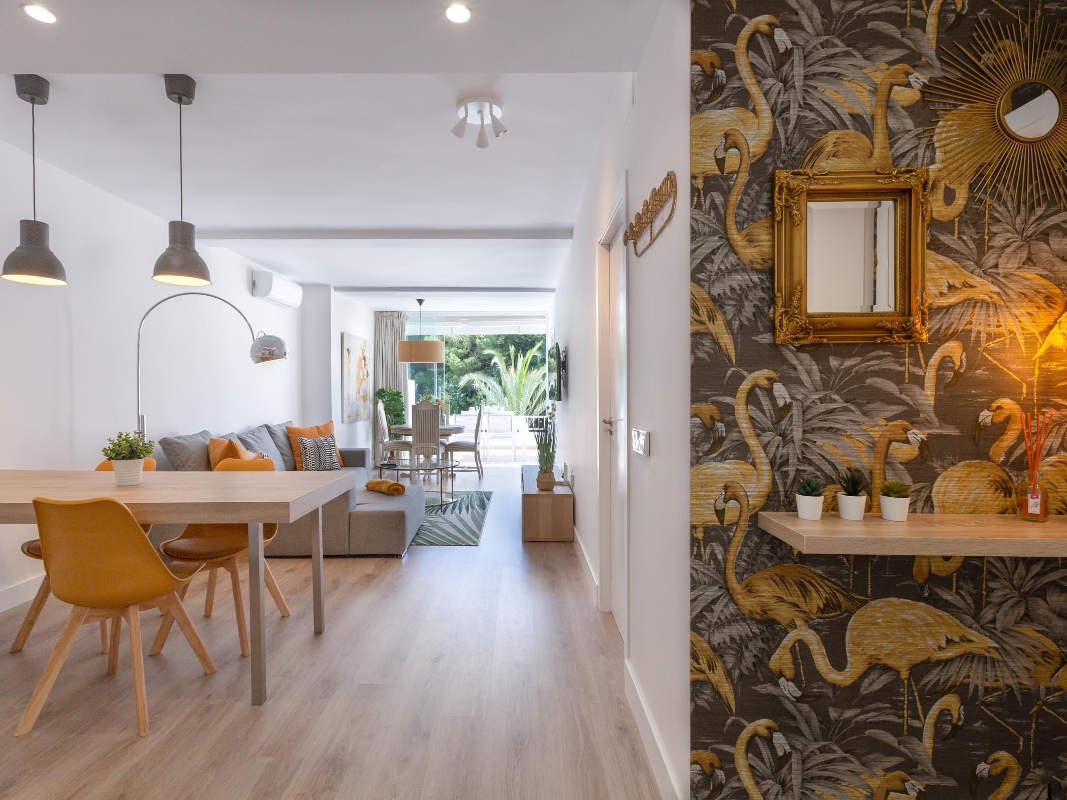 Ein modernes Wohnzimmer mit Essbereich, Blick ins Freie und einer Wand mit Spiegeldekor.