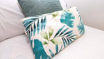 Un lit avec un oreiller à motifs et un autre oreiller orné de motifs de feuilles.