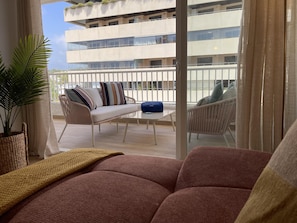 A balcony with a sofa, chairs, and a potted plant. - Beachside Oasis 951 Your refuge by the sea (Marbella)