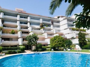A hotel with a swimming pool, multiple balconies, and lush greenery. - Beachside Oasis 951 Your refuge by the sea (Marbella)