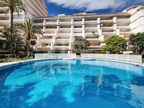 Un hôtel doté d’une piscine, de nombreux balcons et d’une végétation luxuriante.