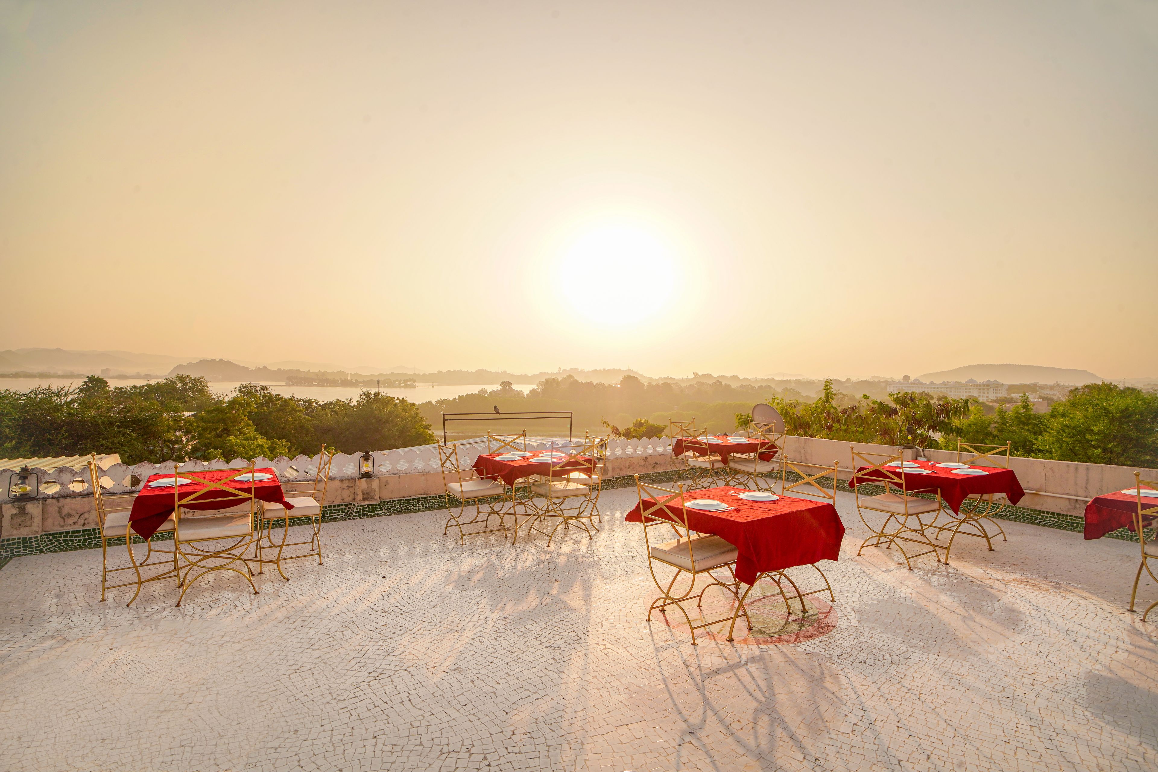 An outdoor dining area with tables and chairs, overlooking a scenic landscape.