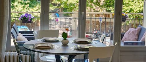 A dining area with a round table set for four, surrounded by chairs.