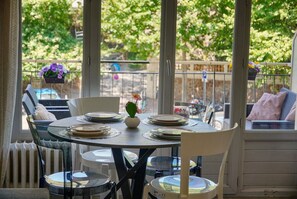 A dining area with a round table set for four, surrounded by chairs. - 14522433 FRGK Stanislas Apartment Terrace, Central (Cannes)