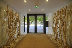 A corridor with a carpeted floor, wooden wall decor, and a door leading outside. - 14522433 FRGK Stanislas Apartment Terrace, Central (Cannes)