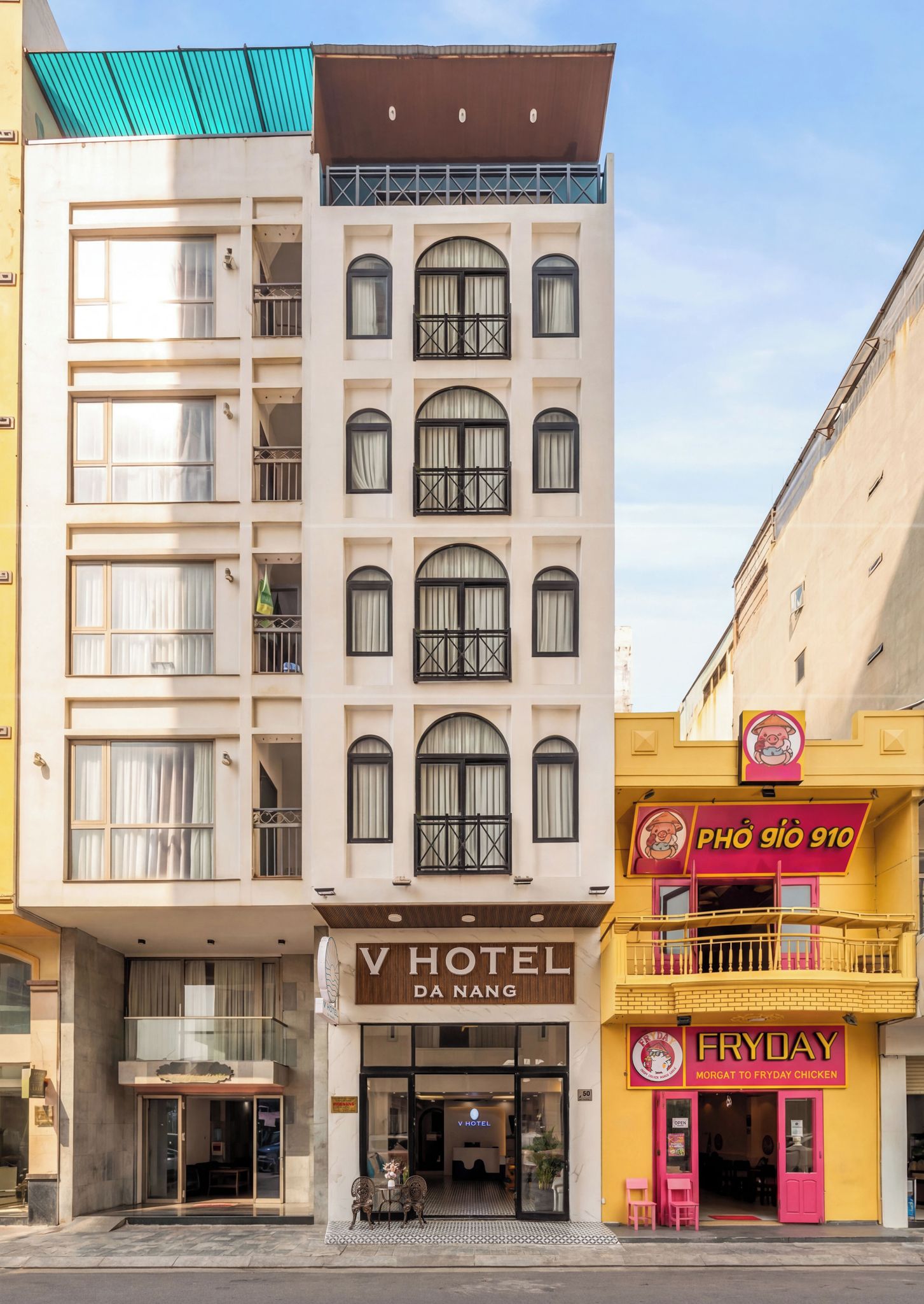 A hotel with a modern facade, a ground-level entrance, and a visible restaurant sign.