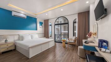 A modern hotel room with a bed, bedside table, and a desk area.