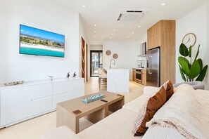 A modern living room with a flat-screen TV, a wooden coffee table, and a sofa with decorative pillows. - Walishali Condo 222 Stunning Community by Bocobay (Noord)