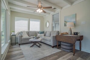 A living room with a sofa, a coffee table, a lamp, and a painting on the wall. - Guadalupe River Retreat (Seguin)