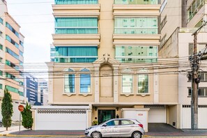 A multi-story building with a beige facade, large windows, and a gated entrance. - Apt. w/ A/C & City View Meia Praia Hpm0801 (Itapema)