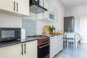 Eine moderne Küche mit Herd, Backofen, Mikrowelle und einem Essbereich mit Tisch und Stühlen.