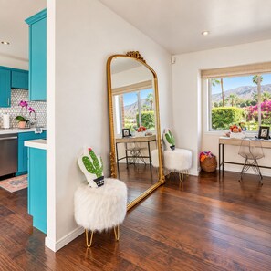 Une cuisine moderne avec des meubles de couleur turquoise, un grand miroir et une vue sur un paysage montagneux.