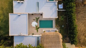 Een woonhuis met zwembad, meerdere kamers en een tuin.