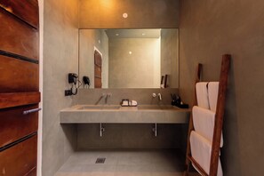 Ein modernes Badezimmer mit großem Spiegel, zwei Waschbecken und einem Holz-Badmöbel