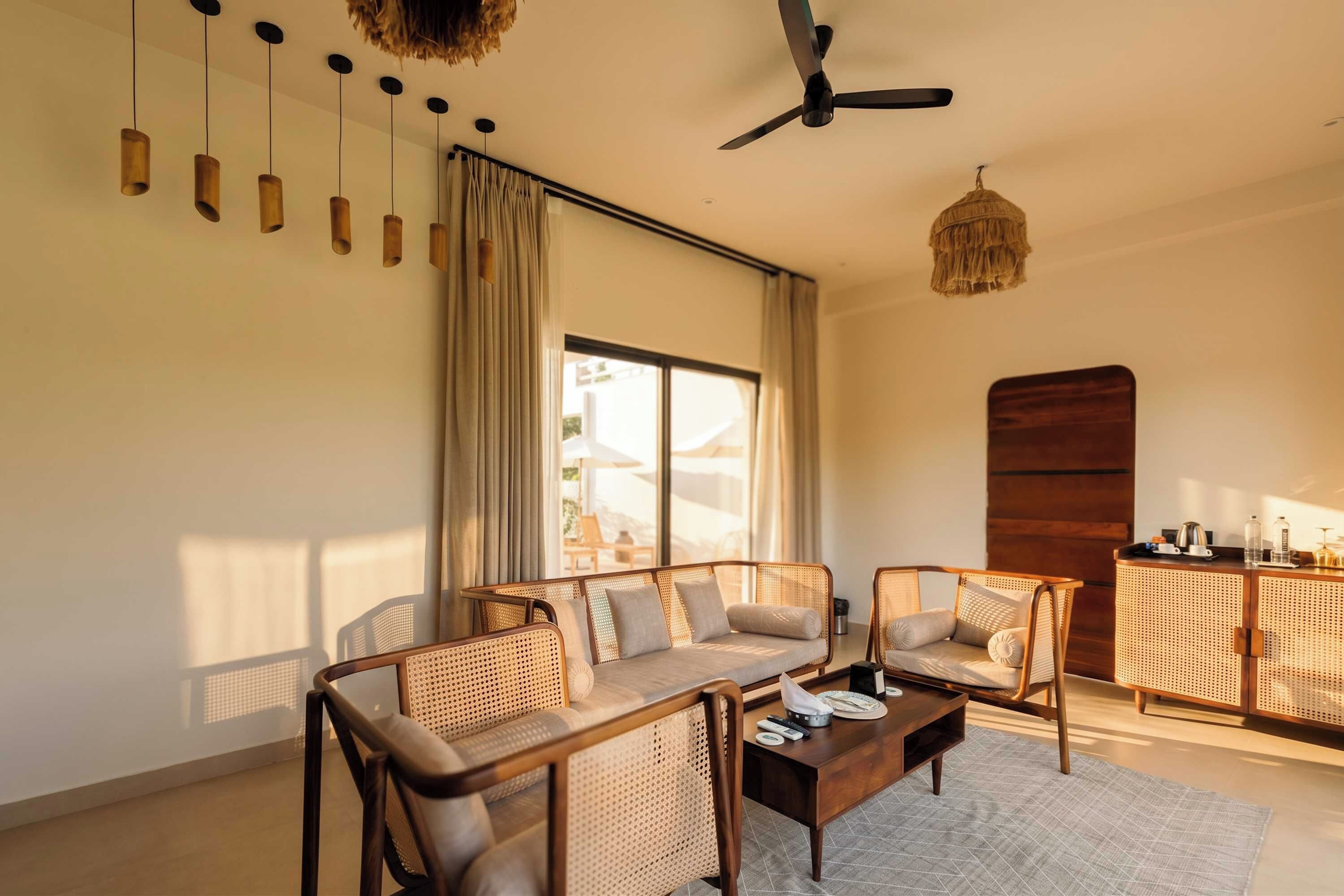 A modern living room with a sofa set, a coffee table, and a ceiling fan.