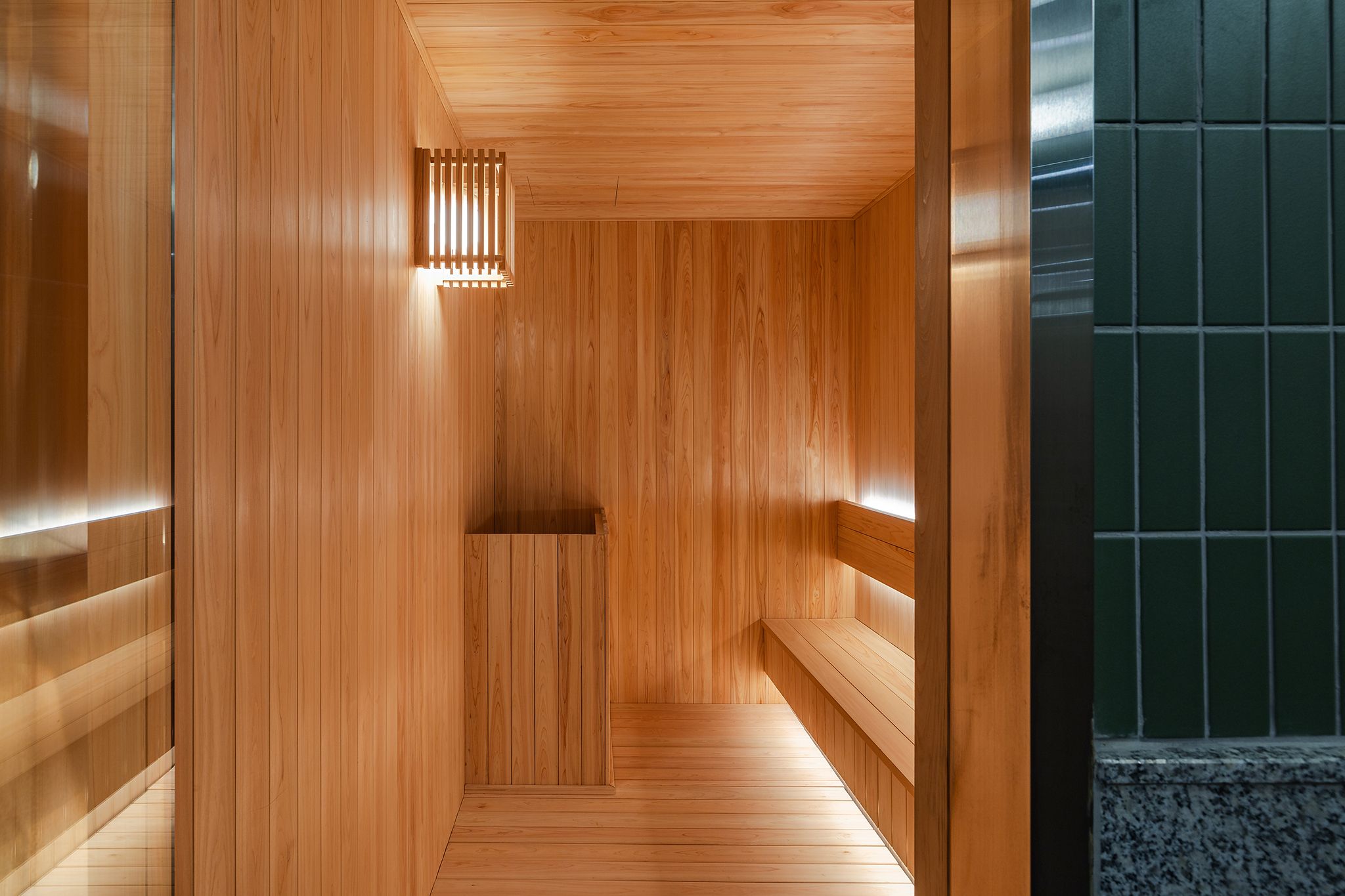 Un sauna de madera con bancos y un banco en el centro.