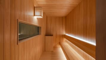 Un interior de madera con un banco, una pantalla montada en la pared y un techo inclinado.