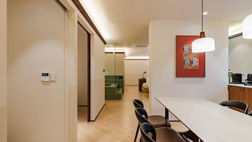 A hotel room with a dining area, a shower, and a bathroom.