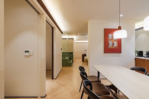 A hotel room with a dining area, a shower, and a bathroom. - Mansion Bridge Cheonan (Cheonan)
