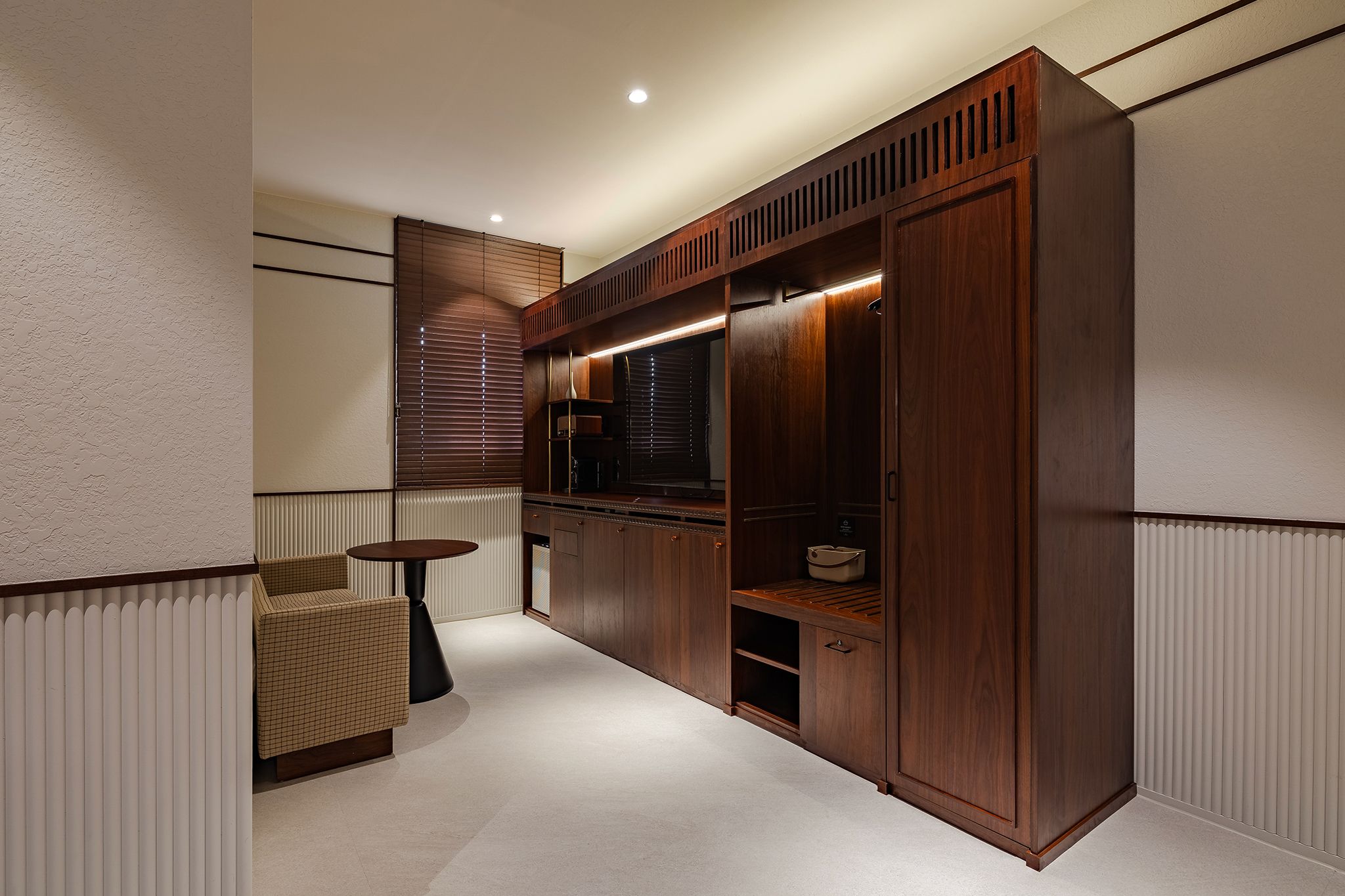 A modern interior with a built-in wardrobe, a round table, and a radiator.