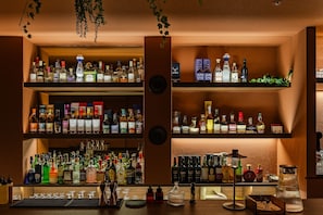 Un bar con múltiples estantes llenos de botellas de licor y vasos.