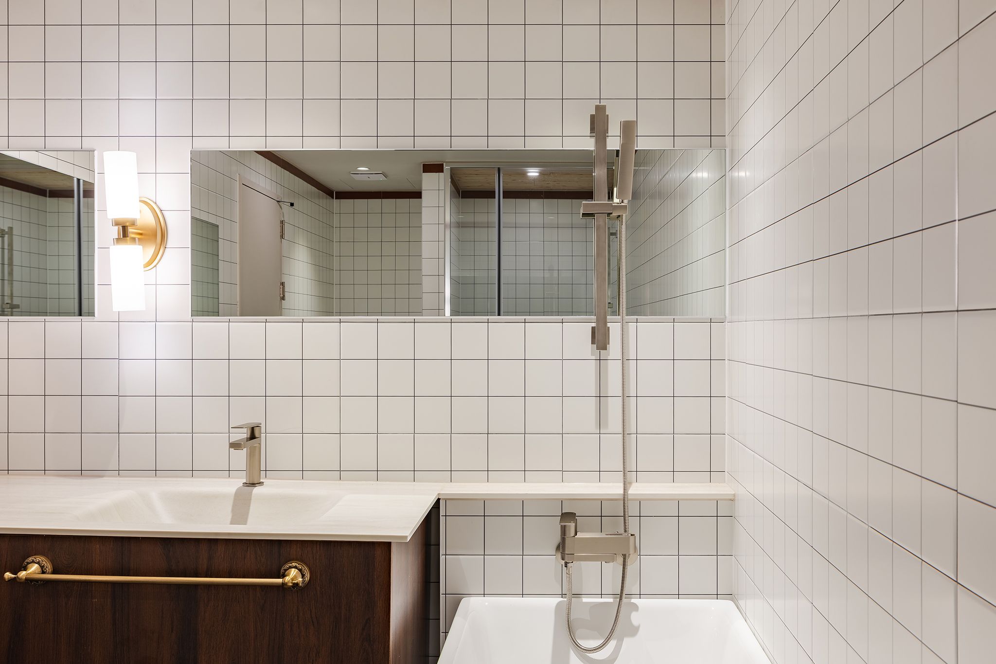 A modern bathroom with a vanity, a bathtub, and a shower.