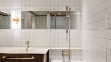 A modern bathroom with a vanity, a bathtub, and a shower.