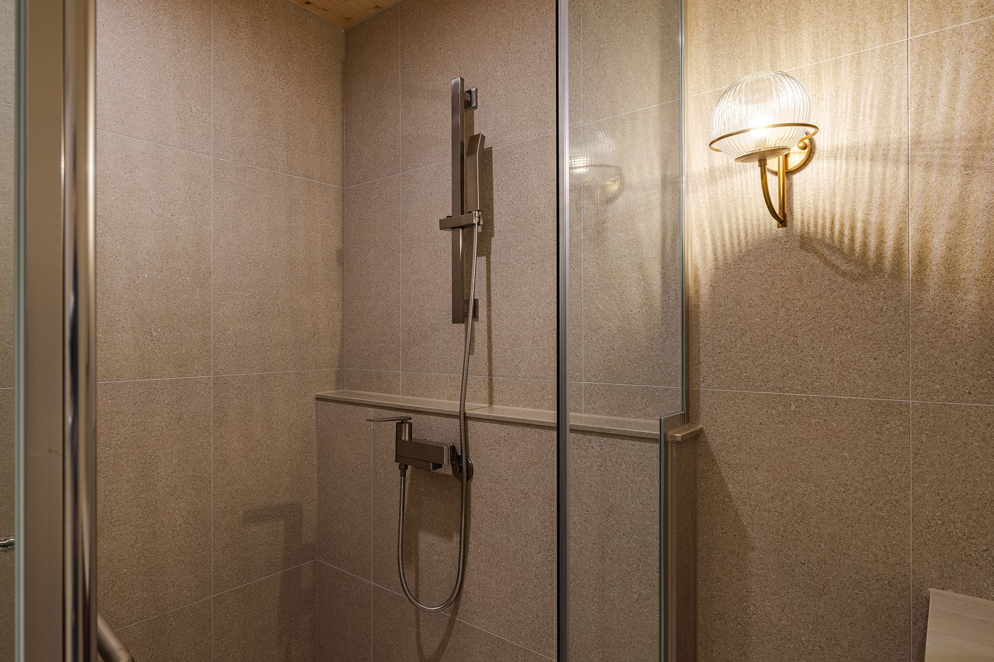 Eine Dusche mit Handbrause und einer fest installierten Bedienfeld.