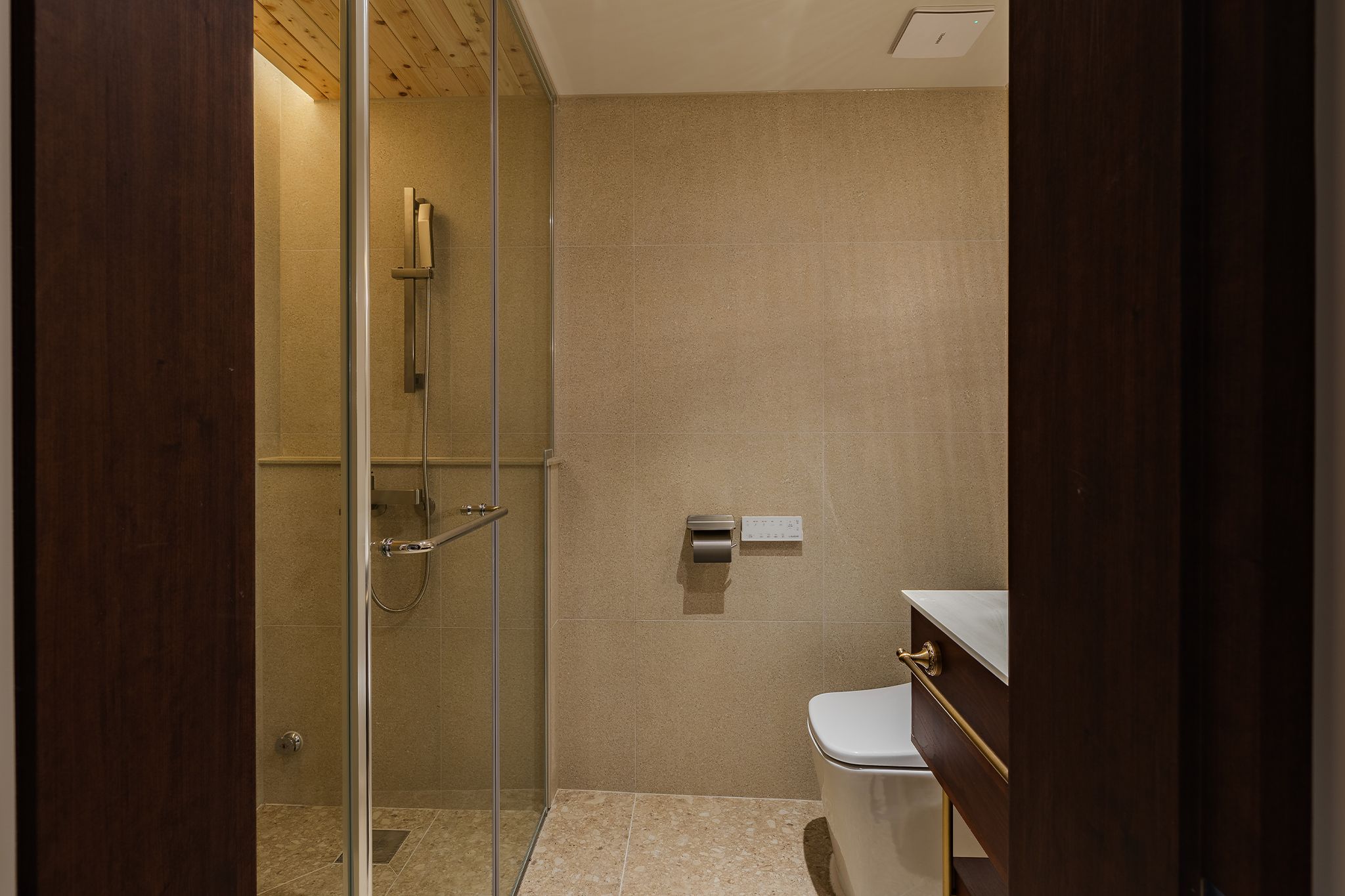 Un baño moderno con ducha envuelta en vidrio, inodoro y tocador con espejo.