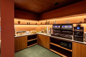 Una cocina compacta con cafetera, tostadora y microondas.