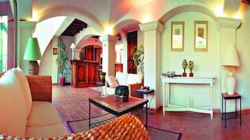Amplia sala de estar con chimenea, asientos y vistas al exterior.