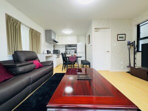 A compact living space with a sofa, a dining table, and a kitchen area. - Tokyo 3-Story Private House, Sleeps 10, Free Parking, Easy Asakusa & Airports (Katsushika City)