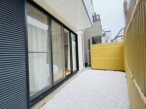 A narrow pathway leading to a building with large windows and a yellow fence. - Tokyo 3-Story Private House, Sleeps 10, Free Parking, Easy Asakusa & Airports (Katsushika City)