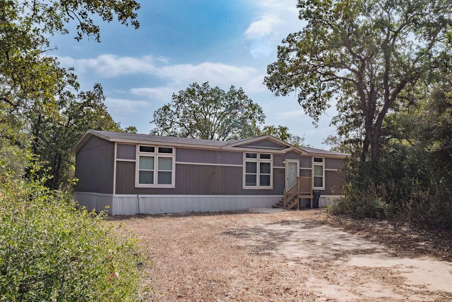 A single-story mobile home with a front porch and a small attached garage.