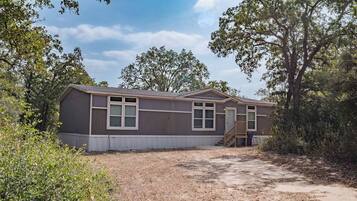 A single-story mobile home with a front porch and a small attached garage.