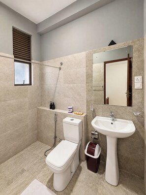 A modern bathroom with a toilet, bidet, shower, and sink. - Ruhe Trail Ella (Ella)