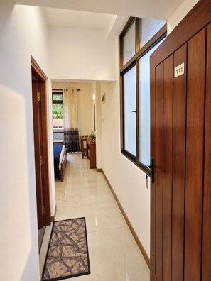 A hallway with a wooden door, a window, and a bench. - Ruhe Trail Ella (Ella)