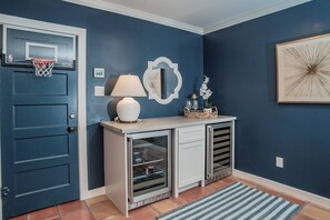 A hallway with a blue door, a basketball hoop, a white lamp, a decorative mirror, and a framed artwork on the wall. - Terminal Wake House-Lake McQueeney (McQueeney)
