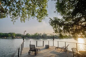 Eine Uferterrasse mit Sitzgelegenheiten im Freien und Blick auf das Wasser.