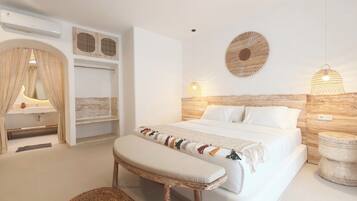A modern bedroom with a large bed, bedside lamps, a vanity with a mirror, and a hanging light fixture.