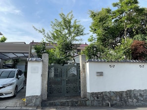 A gated residential area with a white wall, stone base, and a metal gate. - Convenient access to Kamakura, Hakone, and Yokohama! A 3-minute walk from Hiratsuka Station / A traditional Japanese house with a garden and free parking (hiratsuka yaezakityou)