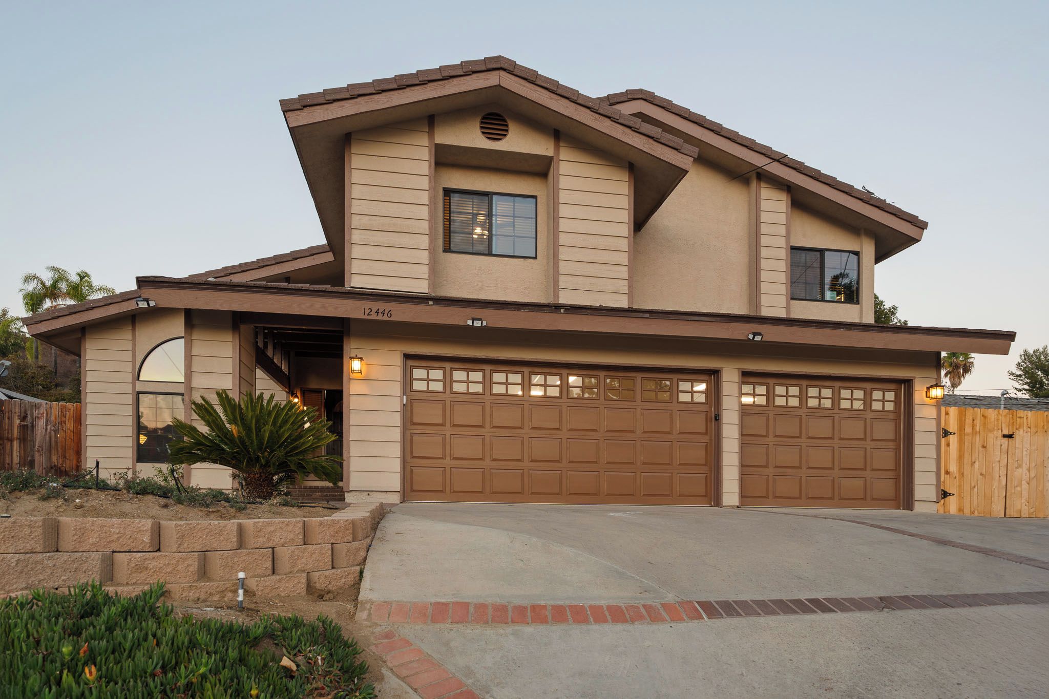 A two-story house with a garage, a covered entryway, and a landscaped front yard.