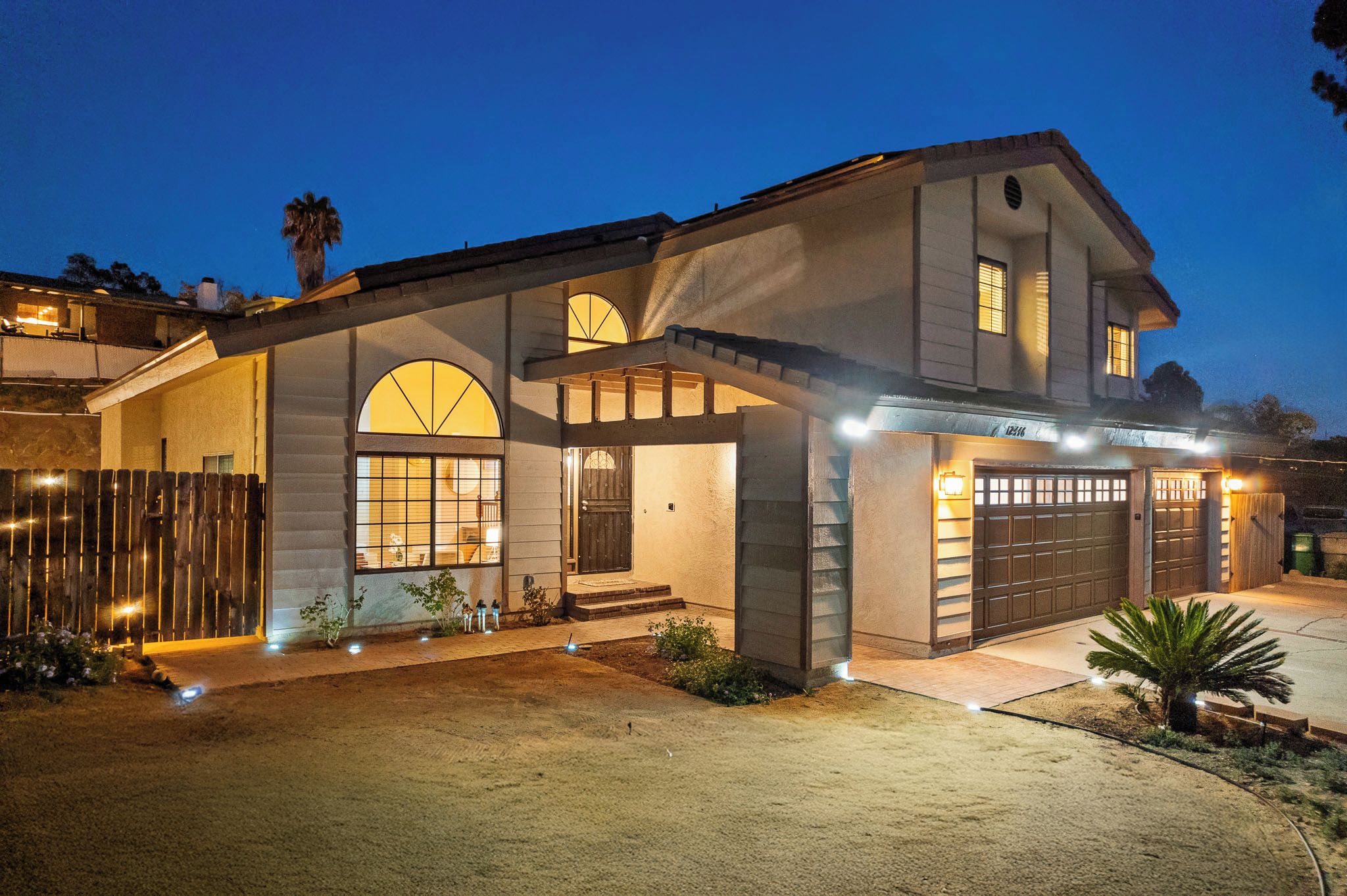 A two-story house with a garage, a covered porch, and a well-lit entrance.